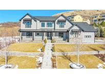 Two-story farmhouse-style home with stone accents and landscaped yard at 359 Castlemaine Ct, Castle Rock, CO 80104