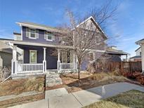Charming two-story home with a welcoming front porch and manicured landscaping at 4940 Akron St, Denver, CO 80238