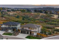 Beautiful two-story home with an attached three-car garage and a meticulously manicured lawn at 6405 Kenzie Cir, Castle Pines, CO 80108