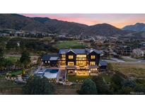 A stunning home featuring a pool, outdoor seating, and views of a nearby golf course nestled in the hills at 7868 Cicero Ct, Littleton, CO 80125