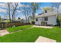 Large backyard with green grass, wood fence and access to an accessory dwelling unit at 1850 S Williams St, Denver, CO 80210
