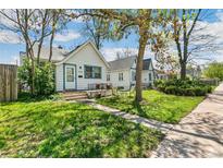 Charming home featuring a quaint front yard with lush green grass and a cozy seating area under a tree at 1850 S Williams St, Denver, CO 80210