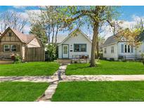 Charming bungalow with a well-maintained lawn, mature tree, and inviting curb appeal at 1850 S Williams St, Denver, CO 80210