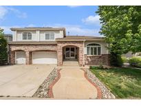 Charming two-story home featuring a brick facade, arched entryway, and a well-manicured front yard at 10155 Charissglen Ln, Littleton, CO 80126