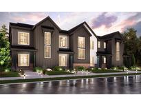 Stunning new build townhome with a modern farmhouse aesthetic, professional landscaping, and inviting exterior lighting at 6872 Huddersfield Ln, Castle Pines, CO 80108