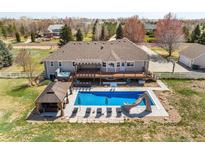 Aerial view of in-ground pool, hot tub, gazebo, large deck, patio and manicured lawn at 212 Mulligan Lake Dr, Mead, CO 80542