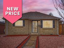 Charming brick home featuring mature landscaping, complemented by an inviting front entrance with storm door at 3020 Niagara St, Denver, CO 80207