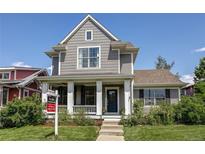 Charming gray two-story home featuring a welcoming front porch and manicured lawn at 3354 Wabash St, Denver, CO 80238