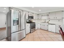 Bright kitchen features stainless steel appliances, ample cabinet space and tile flooring at 12734 Anhawa Ave, Longmont, CO 80503