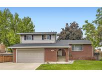 Charming two-story home featuring a brick facade, well-maintained lawn, and an attached two-car garage at 13123 Spica Dr, Lone Tree, CO 80124