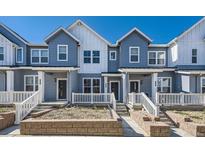 Charming townhouse featuring light blue siding and a well-manicured front yard at 1974 S Haleyville Way, Aurora, CO 80018