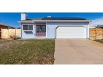 Charming light blue house featuring a two-car garage, new solar panels, and a well-maintained lawn at 1451 S Quitman St, Denver, CO 80219