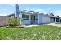 Charming one story home featuring manicured lawn, classic siding, and an attached garage at 1451 S Quitman St, Denver, CO 80219