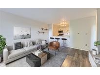 Bright living room featuring contemporary decor, hardwood floors, and an opening to the kitchen at 1008 N Corona St # 403, Denver, CO 80218