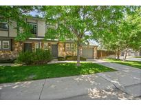 Attractive home exterior with stone accents, a well-manicured lawn, and a two-car garage at 10223 Vine Ct, Thornton, CO 80229