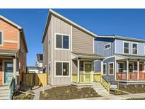 Two-story modern home with gray siding, yellow porch, and landscaping at 10251 E 62Nd Pl, Denver, CO 80238