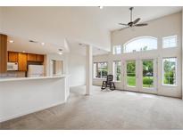 Bright living room featuring high ceilings, a ceiling fan, and sliding glass doors to the outdoor space at 10725 Eliot Cir # 102, Denver, CO 80234