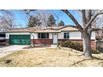 Charming single-story home featuring a green garage door, brick accents, and a well-maintained front yard at 7559 Jay Ct, Arvada, CO 80003