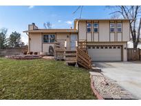 Inviting home with two-car garage, featuring a charming front yard and quaint wooden staircase at 8757 Estes Ct, Arvada, CO 80005