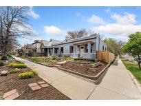 Charming light blue bungalow with tidy yard and garden, front view from sidewalk at 3059 N Humboldt St, Denver, CO 80205