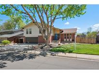 Charming two-story home with brick accents, attached garage, a mature tree, and well-maintained lawn at 3832 S Quebec St, Denver, CO 80237