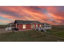 Charming single-story home with a welcoming front porch and vibrant exterior paint at 66095 E Kettle Pl, Byers, CO 80103