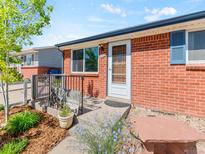 Charming brick home with a welcoming front entrance, landscaped garden, and inviting bench at 4163 S Decatur St, Englewood, CO 80110