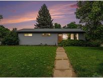 Charming single-story home with a well-manicured lawn and inviting walkway at sunset at 1694 S Elm St, Denver, CO 80222
