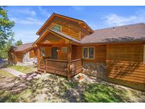 Charming wood cabin featuring a stone foundation, a covered front porch and a picturesque natural setting at 10333 Georgia Cir, Morrison, CO 80465