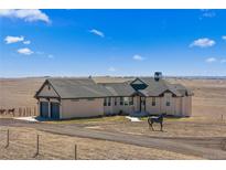 Stunning stucco home with a circular driveway and a horse statue on a vast, open landscape at 7600 Patrick Trl, Elizabeth, CO 80107