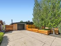 Spacious driveway with an attached garage and a modern horizontal fence surrounding the front yard at 170 W Midway Blvd, Broomfield, CO 80020