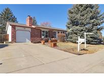 Charming brick home featuring a spacious driveway, attached garage, and well-maintained front yard at 1755 S Yampa Way, Aurora, CO 80017