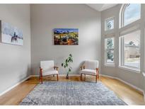 Bright living room featuring large windows, artwork, and cozy seating arrangement at 5075 Weeping Willow Cir, Highlands Ranch, CO 80130