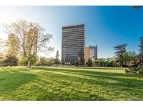 Beautiful building with expansive green space, landscaping, and city views on a sunny day at 1201 N Williams St # 4C, Denver, CO 80218
