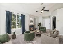 Staged living room features a gas fireplace, large picture window, and modern decor at 4076 S Carson St # H, Aurora, CO 80014
