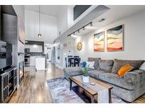 Open-concept living space with high ceilings, modern lighting, and stylish decor at 2541 S Bahama Cir # E, Aurora, CO 80013