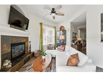 Inviting living room with a fireplace, mounted TV, plush white seating, and stylish decor at 2100 N Humboldt St # 208, Denver, CO 80205