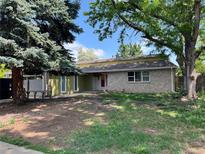 Charming single-story home with a brick facade and a red front door at 5063 W Radcliff Ave, Denver, CO 80236