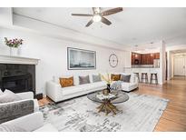 Bright living room features modern decor, fireplace, hardwood floors, and an open floor plan at 1699 N Downing St # 302, Denver, CO 80218