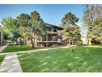 Multi-story apartment building with balconies, mature trees, and a well-maintained lawn at 600 Manhattan Dr # 4C, Boulder, CO 80303
