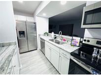 This kitchen features stone countertops, stainless steel appliances and tiled floors at 12223 E Ford # 12223, Aurora, CO 80012