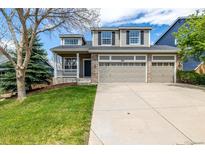 Charming two-story home features a large driveway and an attached three car garage at 1041 Riddlewood Rd, Highlands Ranch, CO 80129