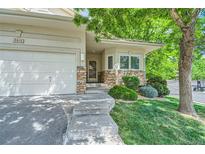 Inviting exterior featuring a stone facade, attached garage, and manicured landscaping at 2616 S Kipling Ct, Lakewood, CO 80227