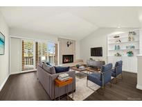 Bright living room with vaulted ceilings, fireplace, and sliding doors to the outside, creating an airy and inviting space at 6300 W Mansfield Ave # 61, Denver, CO 80235