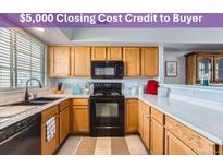 Well-lit kitchen features a black microwave and oven, light wood cabinets, and lots of counter space at 8199 Welby Rd # 3102, Denver, CO 80229
