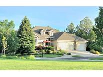 Charming home with a three-car garage, manicured front lawn, and mature trees at 24733 E Park Crescent Dr, Aurora, CO 80016
