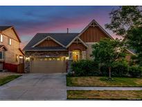 Charming exterior view of a two-story home featuring a stone and siding facade, well-maintained landscaping and driveway at 10221 Nucla St, Commerce City, CO 80022