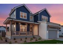 Stunning two-story home showcasing a modern design with blue siding, a white brick facade, and a welcoming front porch at 1426 Swan Peter Dr, Berthoud, CO 80513