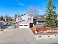 Charming two-story home featuring a well-manicured front yard and an attached two-car garage at 1691 S Arbutus Pl, Lakewood, CO 80228