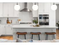 Modern kitchen with white cabinets, stainless steel appliances, and quartz countertops at 3589 Rucksack Ct, Castle Rock, CO 80108